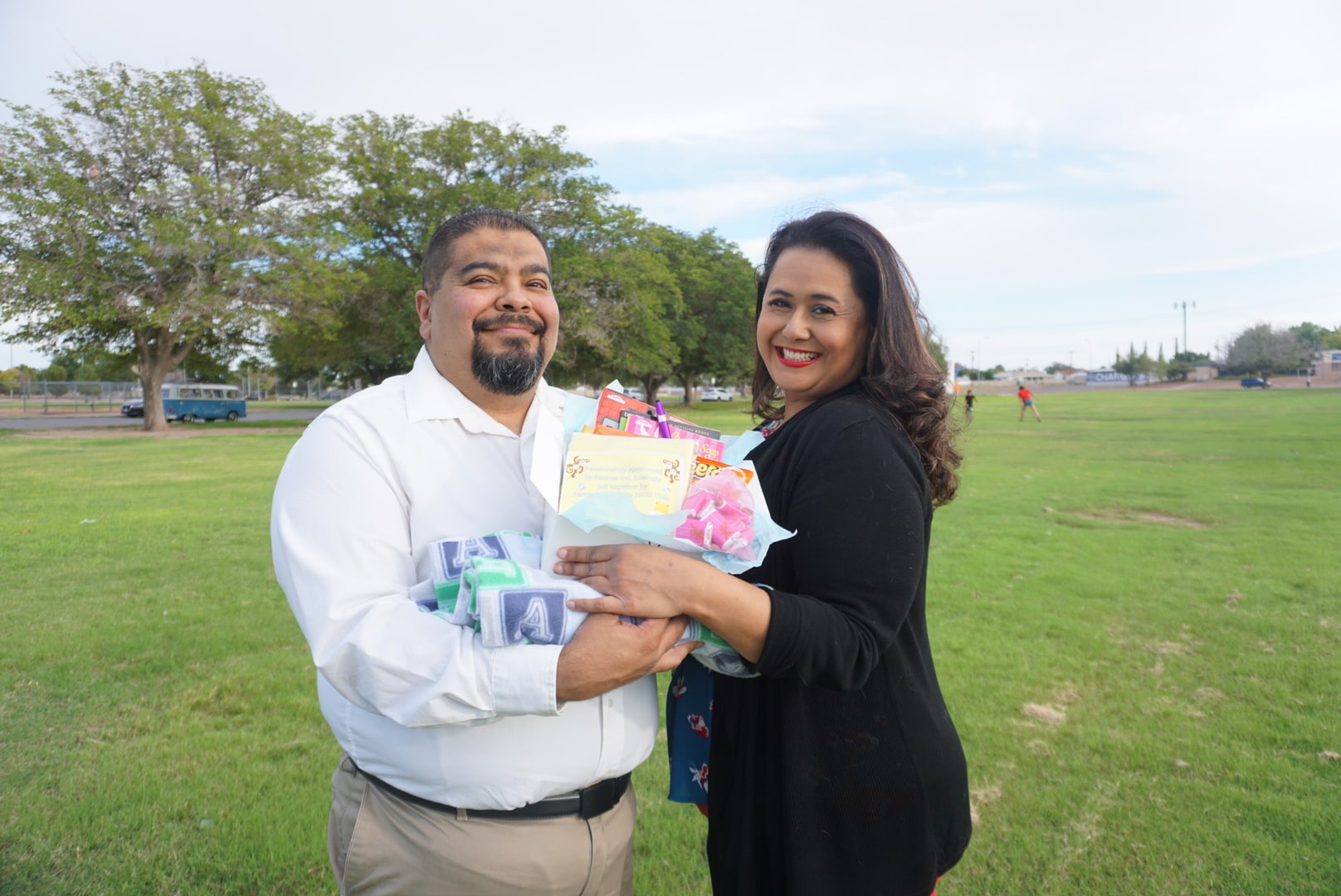 Two people presenting an Aaron Alexander NICU Club care package