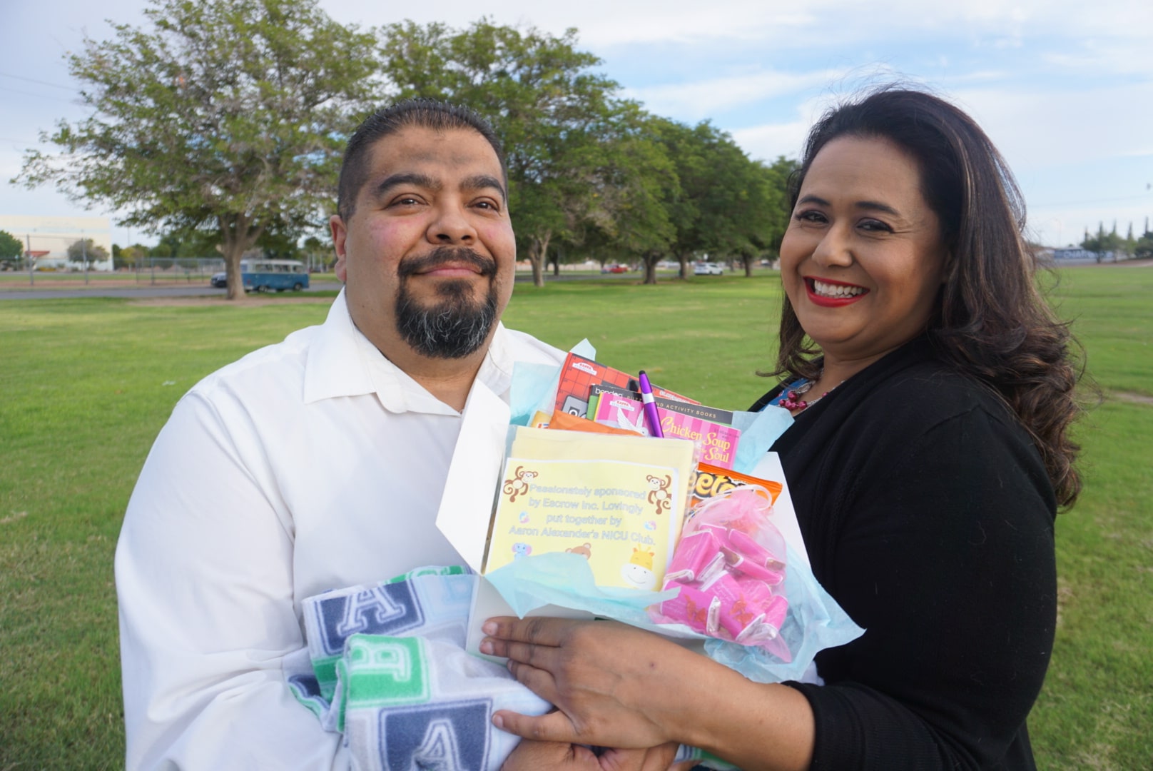 Two people holding an Aaron Alexander NICU Club care package